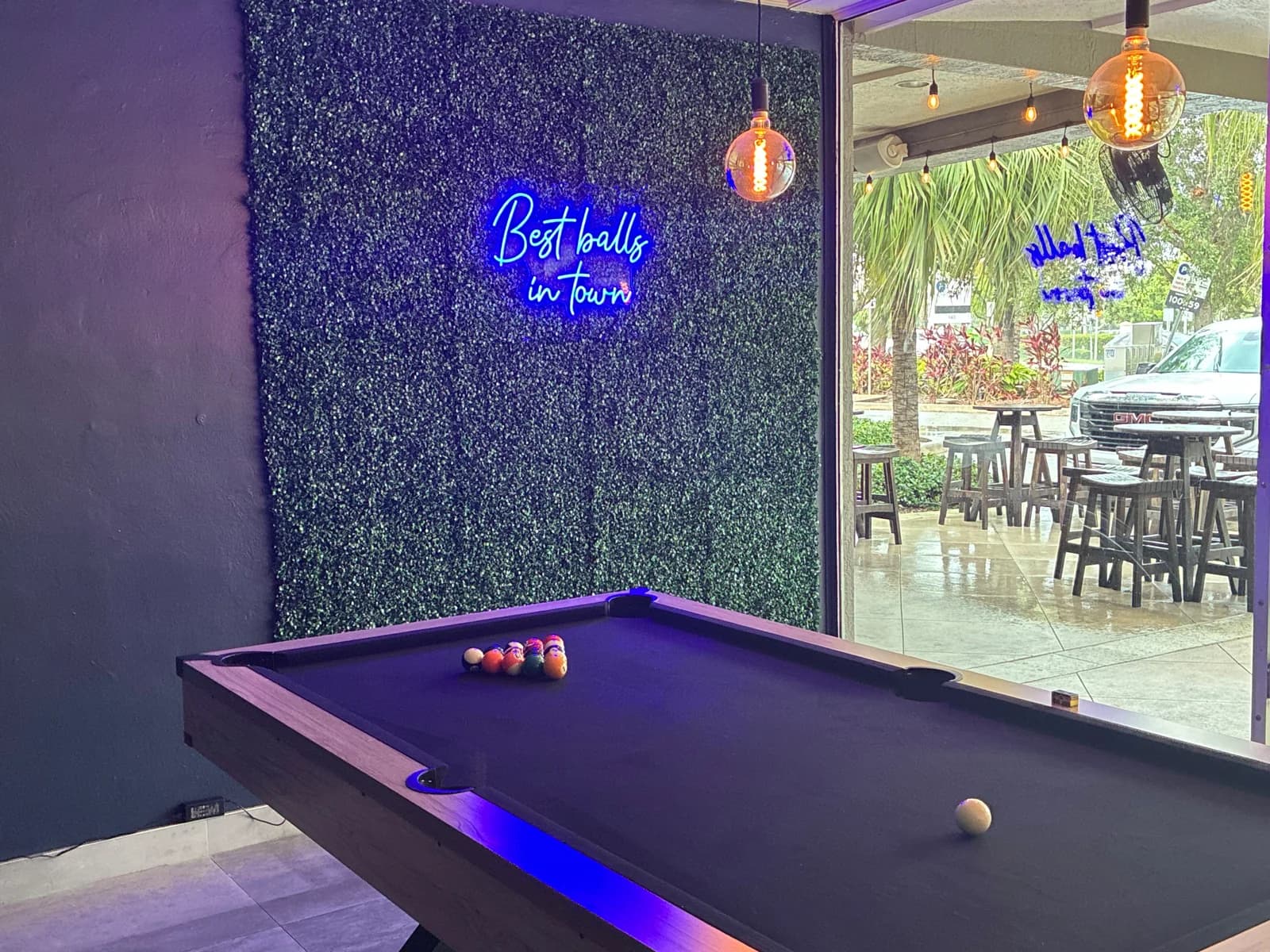 Pool table beside the green wall and sunlit front windows at Zeus